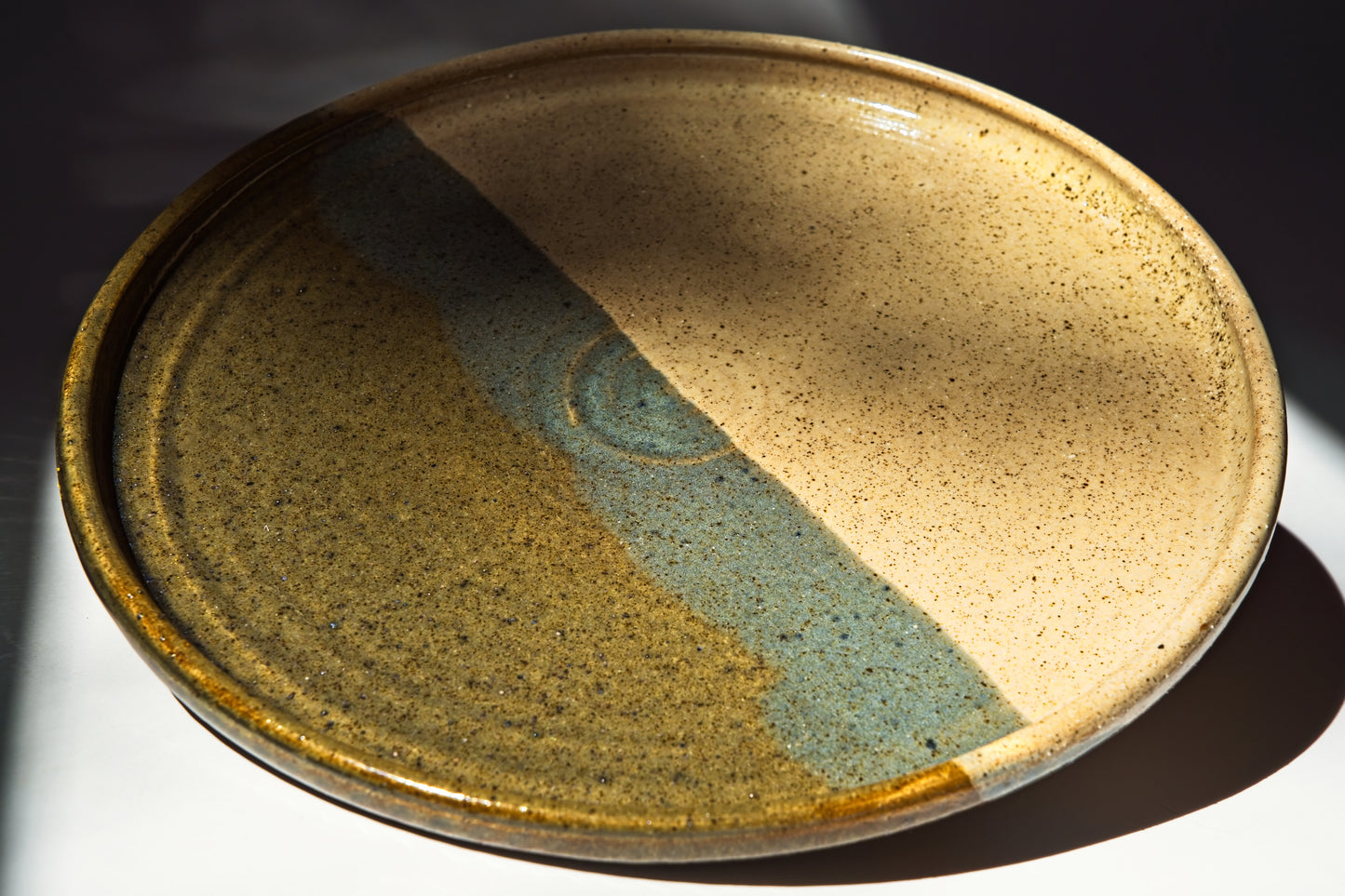 Ceramic plate with two-tone glaze on a dark background