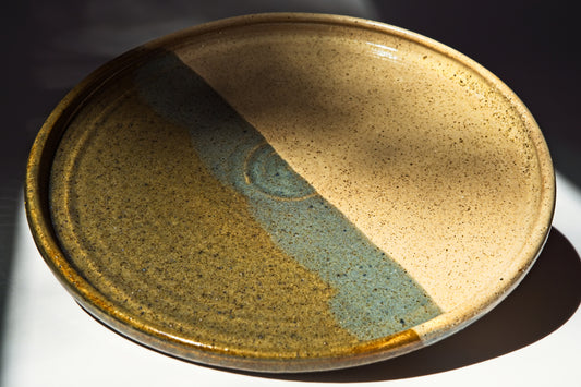 Ceramic plate with two-tone glaze on a dark background