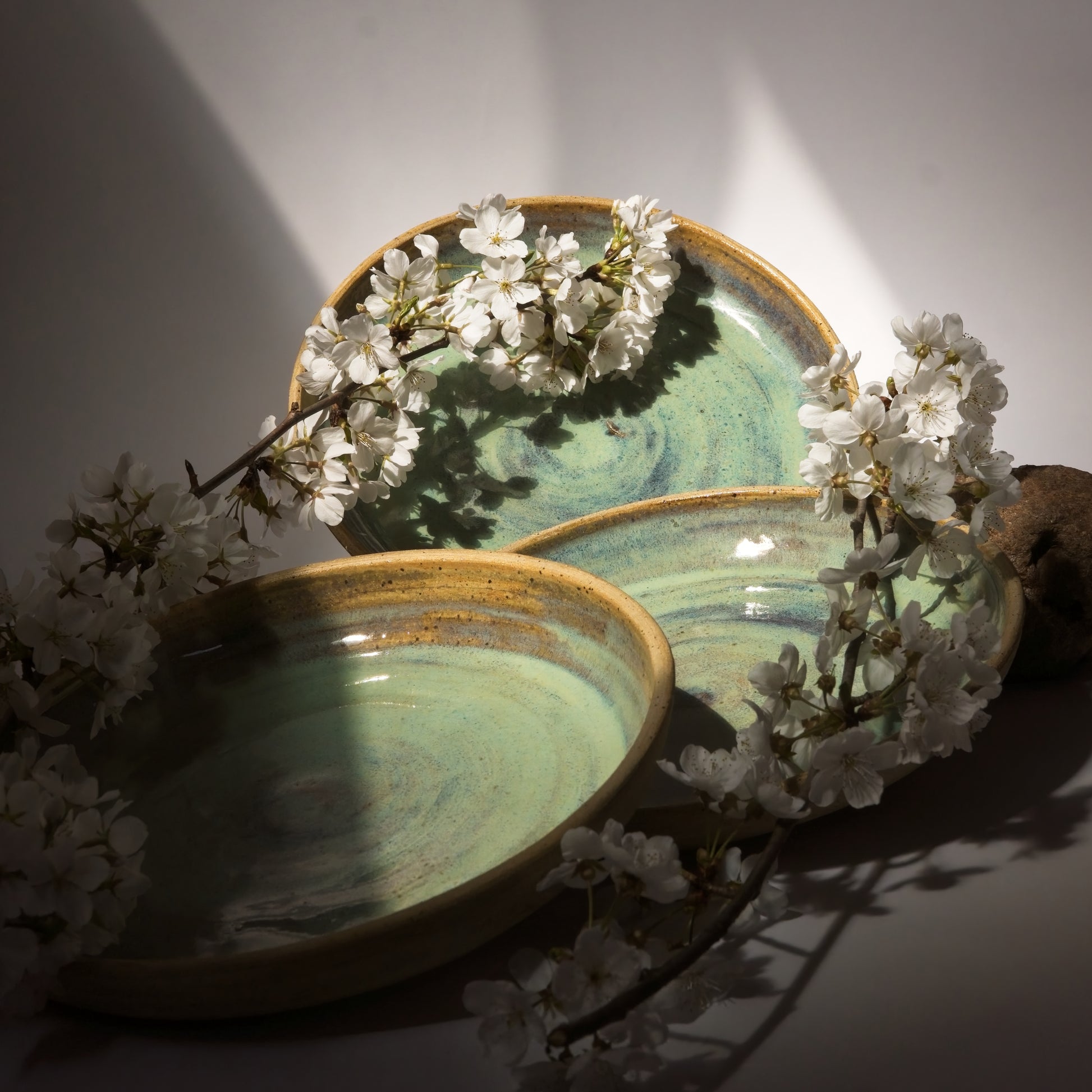 Three ceramic plates with a floral arrangement on a neutral background